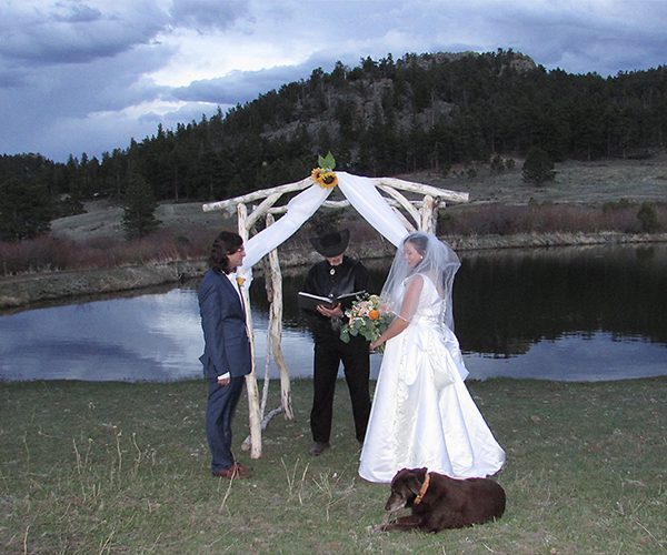 couple exchanging vows at the ranch pond